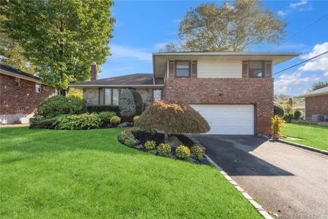a front view of a house with a garden and plants