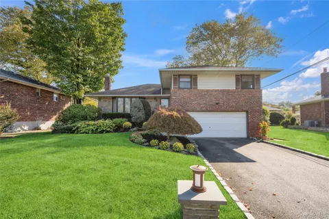 a front view of a house with a garden and yard