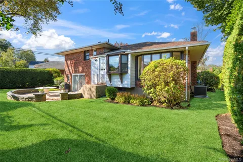a view of a house with backyard sitting area and garden
