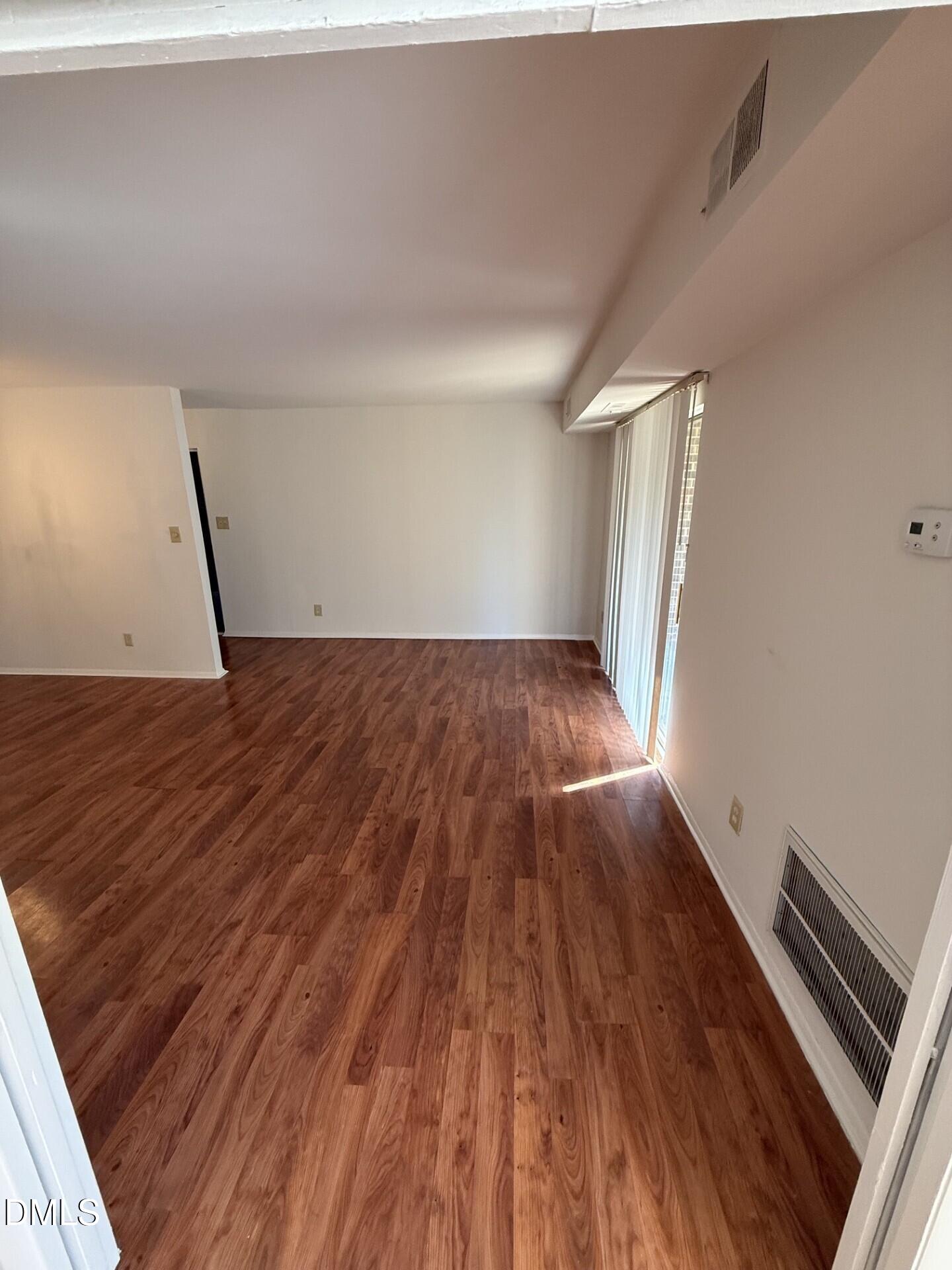 1299 Schaub Drive, Unit D Raleigh, NC 27606 - Photo 4 of 16 a view of an empty room and wooden floor
