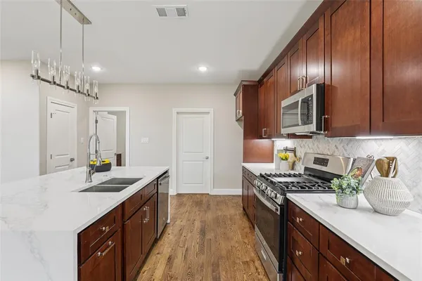 a kitchen with stainless steel appliances granite countertop counter space cabinets a sink and a center