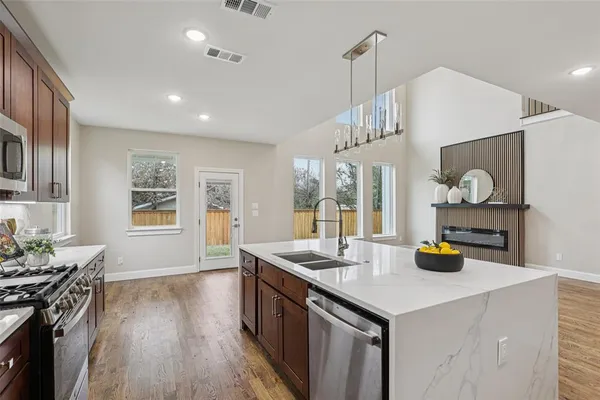 a kitchen with a sink a stove and chairs