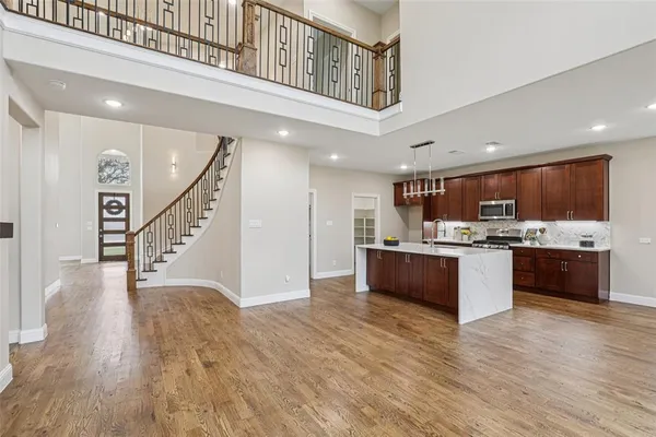 a large white kitchen with a large counter top and stainless steel appliances