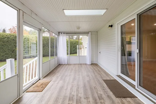 a view of hallway with wooden floor and furniture
