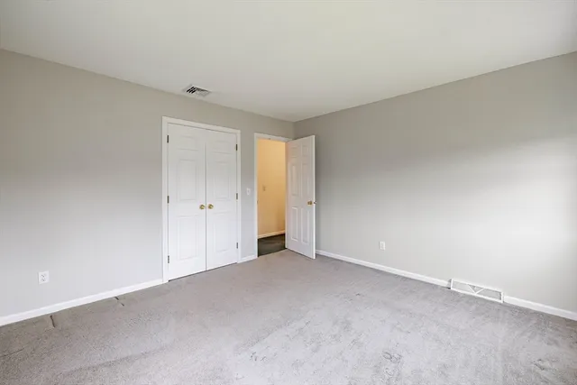 an empty room with windows and closet