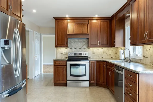 a kitchen with stainless steel appliances granite countertop a stove a refrigerator and a sink