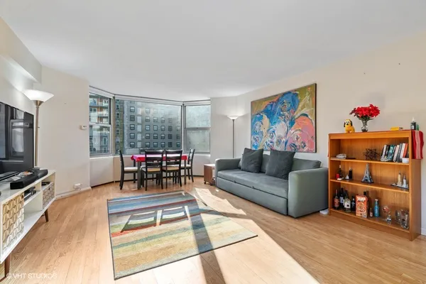 a living room with furniture a flat screen tv and a floor to ceiling window