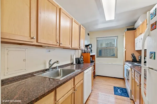 a kitchen that has a sink cabinets counter space and appliances