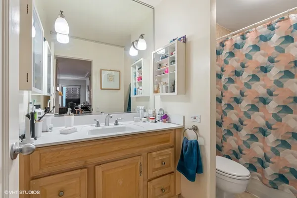 a bathroom with a sink vanity mirror and toilet