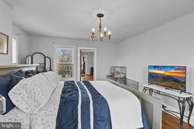 a bedroom with a large bed and a chandelier