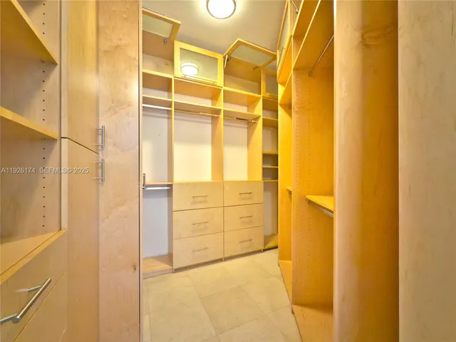 a bathroom with a granite countertop sink two mirror a bathtub and a shower