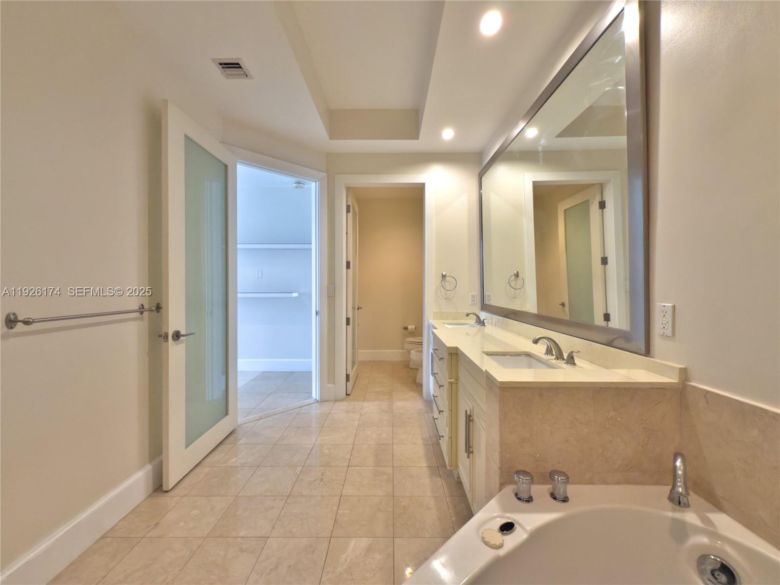 848 Brickell Key Drive, Unit 306 Miami, FL 33131 - Photo 17 of 66 a bathroom with a tub sink and mirror