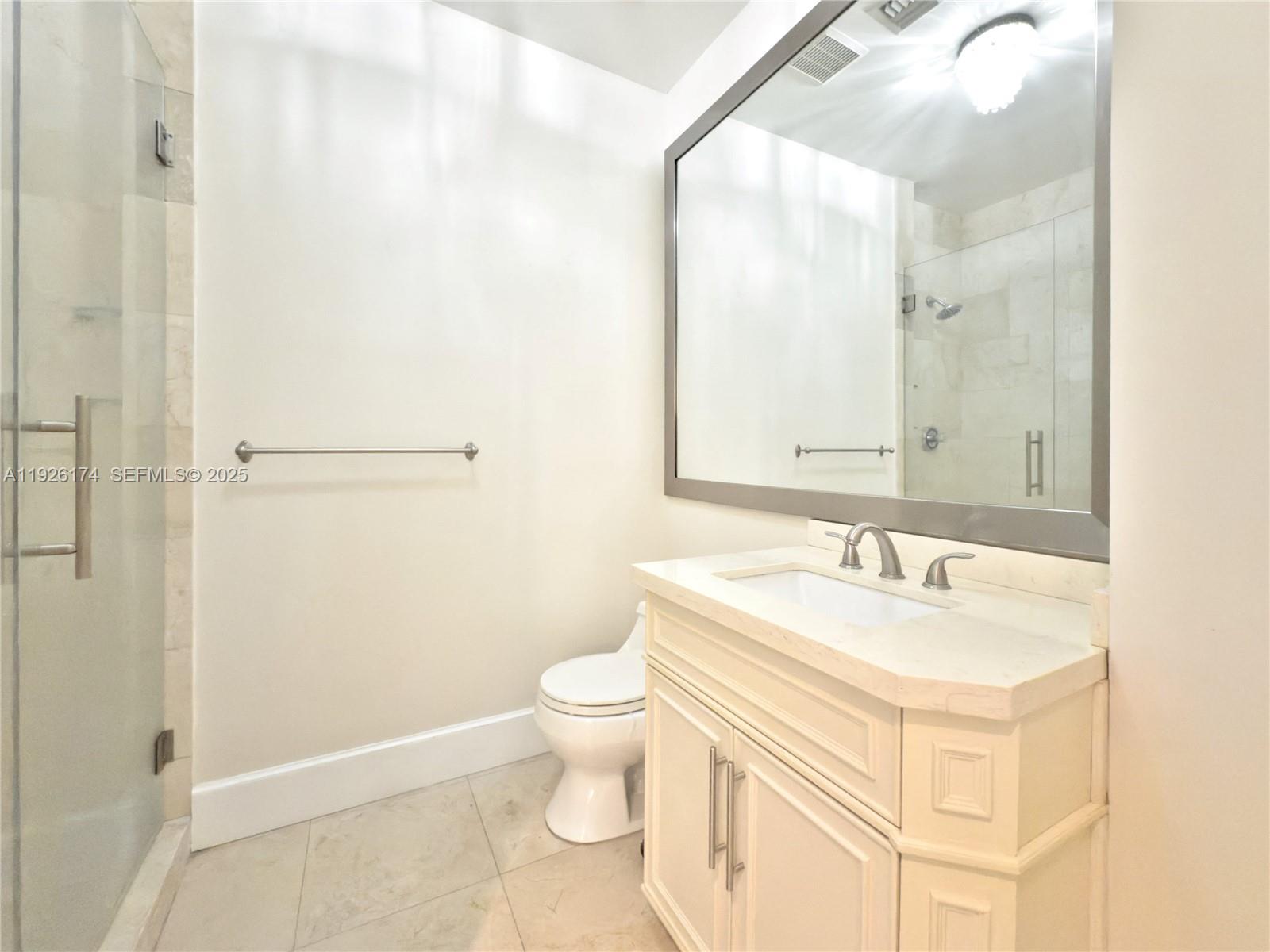 848 Brickell Key Drive, Unit 306 Miami, FL 33131 - Photo 20 of 66 a bathroom with a sink a toilet and a mirror