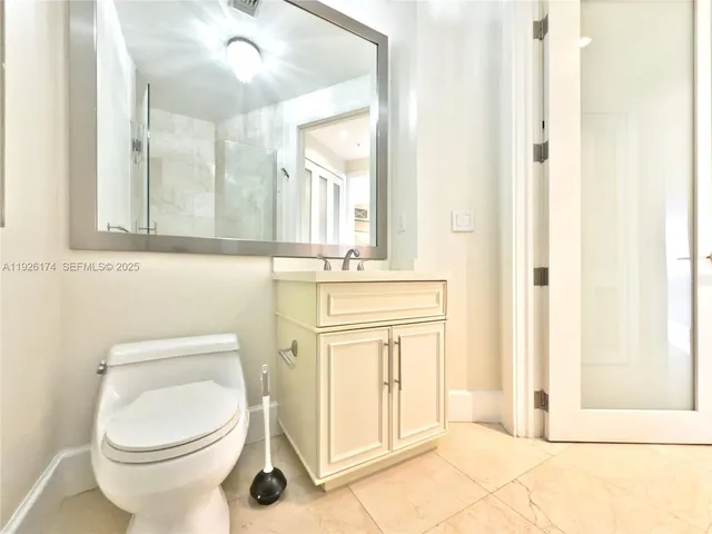 a bathroom with a granite countertop double vanity and a mirror