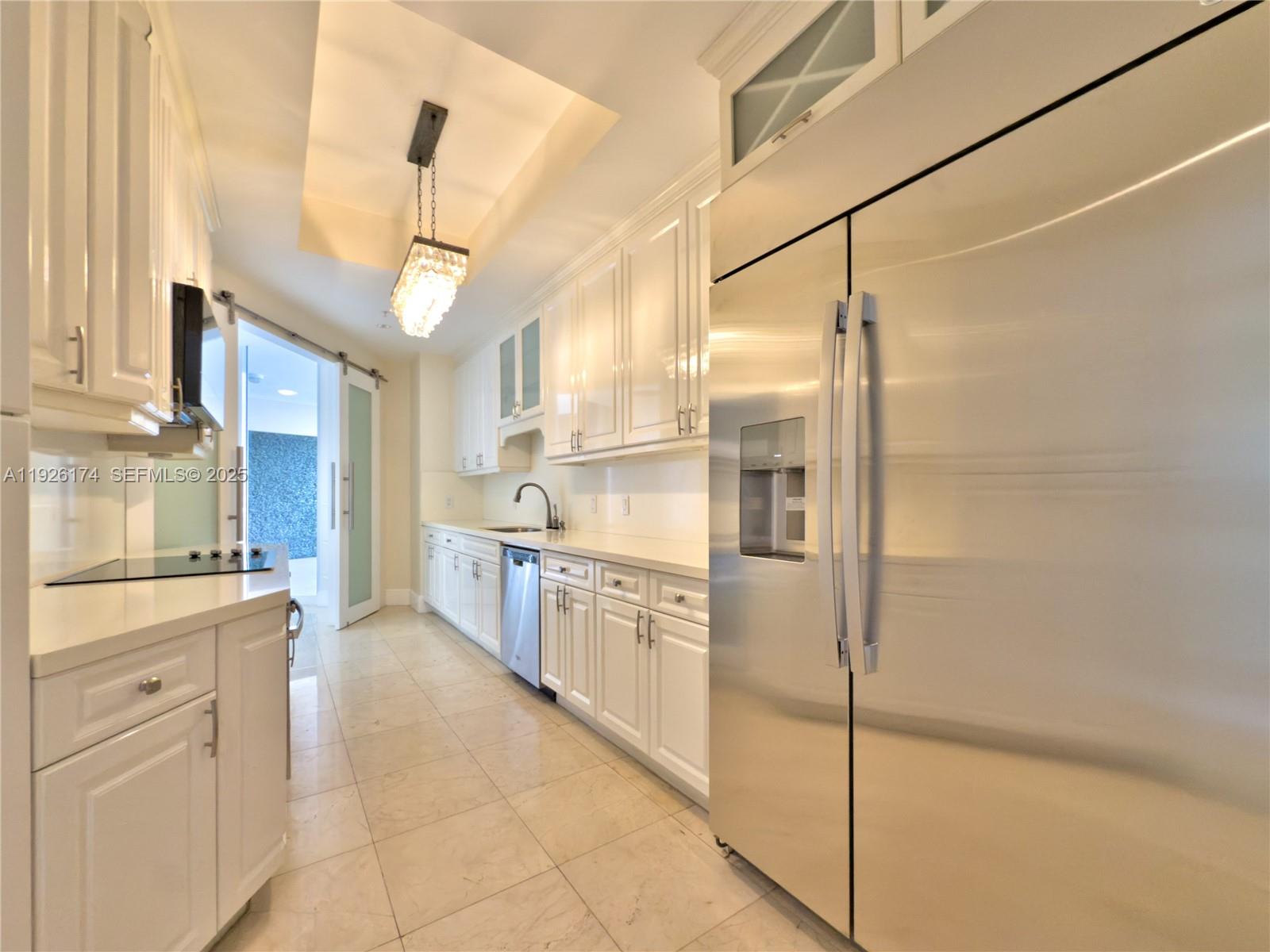 848 Brickell Key Drive, Unit 306 Miami, FL 33131 - Photo 27 of 66 a kitchen with white cabinets and white appliances