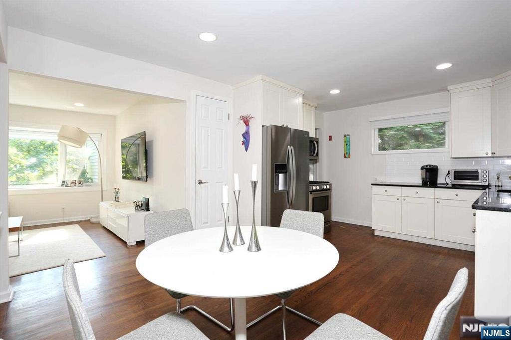 11 Evans Road Cresskill, NJ 07626 - Photo 12 of 31 a kitchen with stainless steel appliances a dining table chairs and a refrigerator
