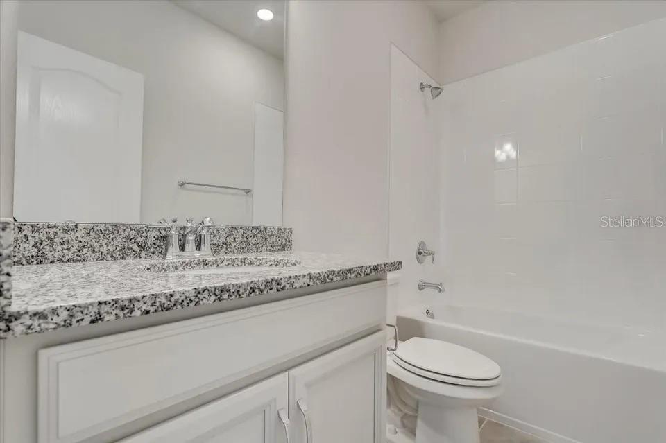 1851 Terrapin Road Ocoee, FL 34761 - Photo 17 of 22 a bathroom with a granite countertop sink a toilet and a bathtub