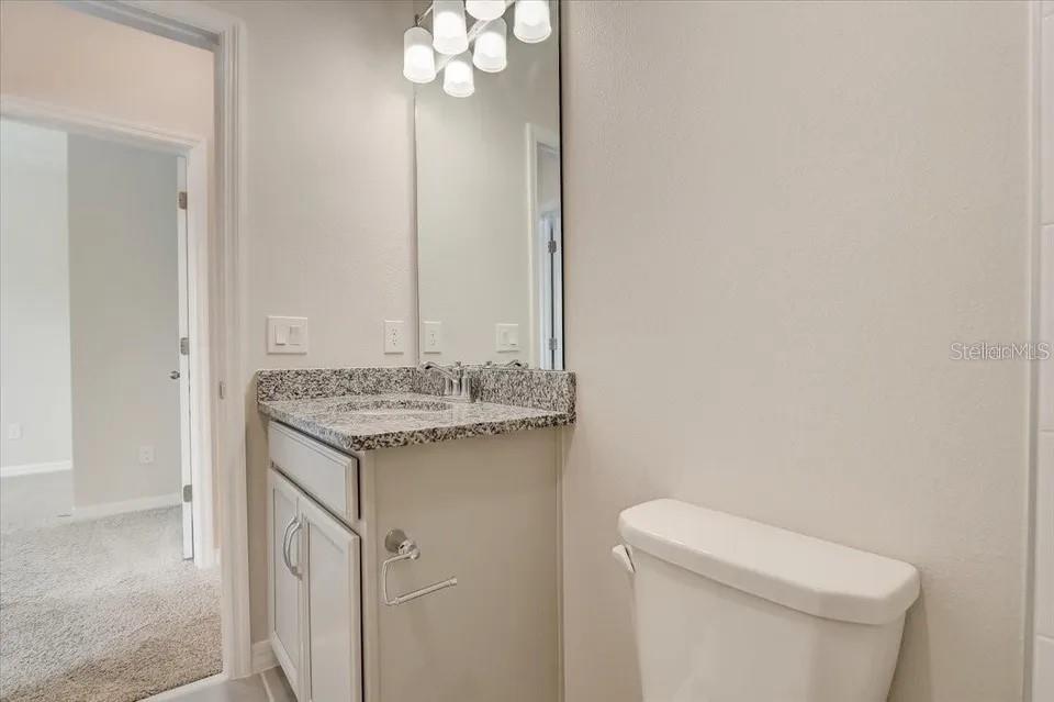1851 Terrapin Road Ocoee, FL 34761 - Photo 18 of 22 a bathroom with a granite countertop sink and a toilet