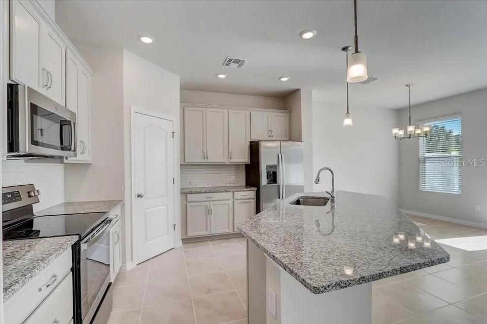 1851 Terrapin Road Ocoee, FL 34761 - Photo 5 of 22 a kitchen with stainless steel appliances granite countertop a sink refrigerator and cabinets