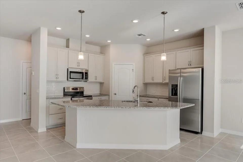 1851 Terrapin Road Ocoee, FL 34761 - Photo 6 of 22 a kitchen with stainless steel appliances granite countertop a sink a stove a refrigerator and white cabinets