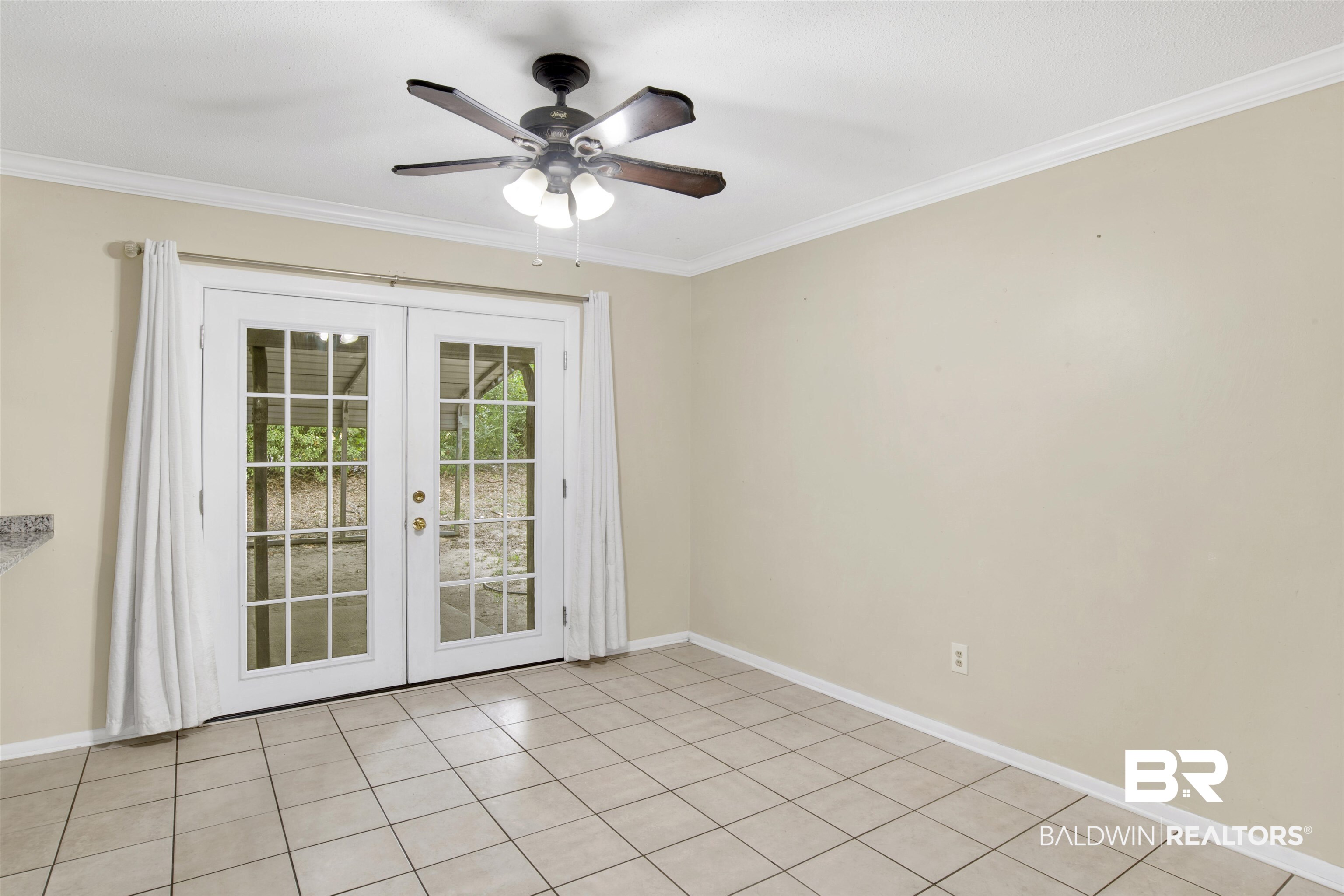 3560 Creekway Road Mobile, AL 36619 - Photo 8 of 24 Tiled empty room featuring ceiling fan, french doors, and ornamental molding