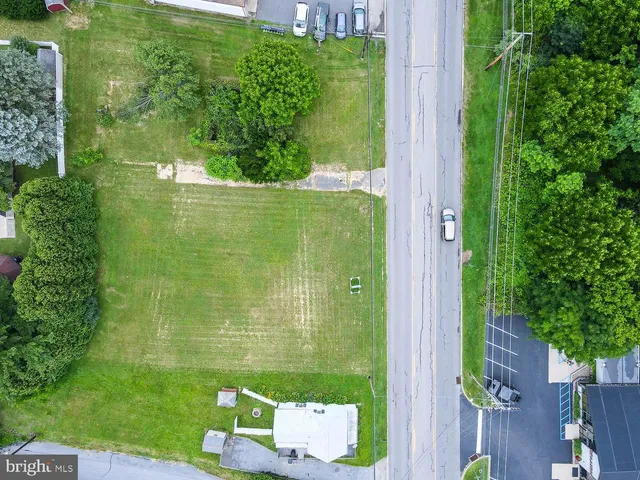 an aerial view of residential houses with outdoor space and street view