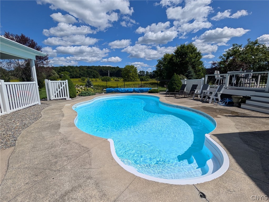 1322 Sawmill Road Sangerfield, NY 13480 - Photo 6 of 50 A concrete patio surrounds a sparkling swimming pool overlooking pastoral countryside views.