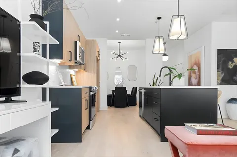 a view of a kitchen with stainless steel appliances kitchen island granite countertop a refrigerator a sink a stove and a microwave