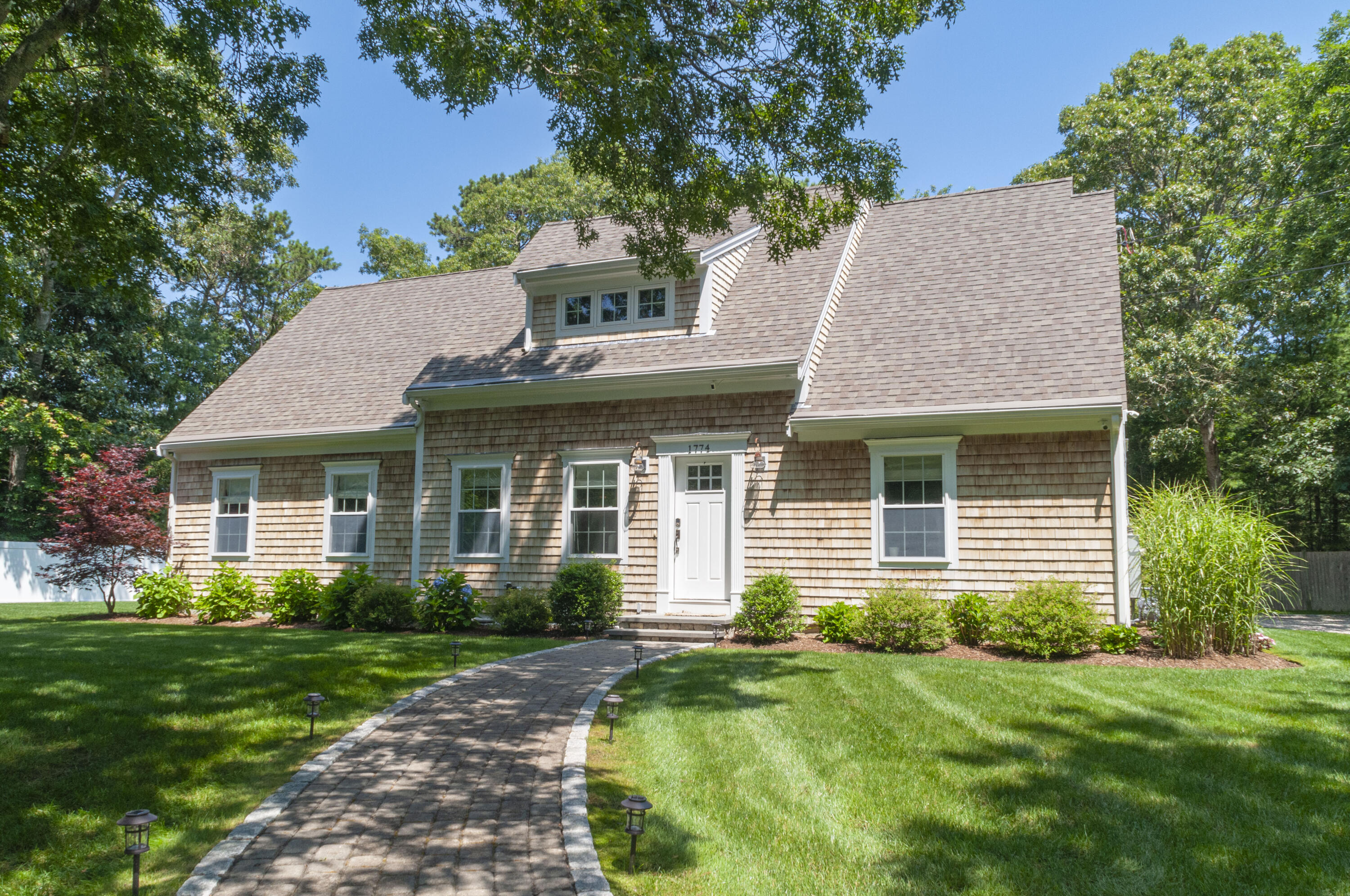 1774 South County Road Osterville, MA 02655 - Photo 2 of 75 a front view of a house with a yard and potted plants