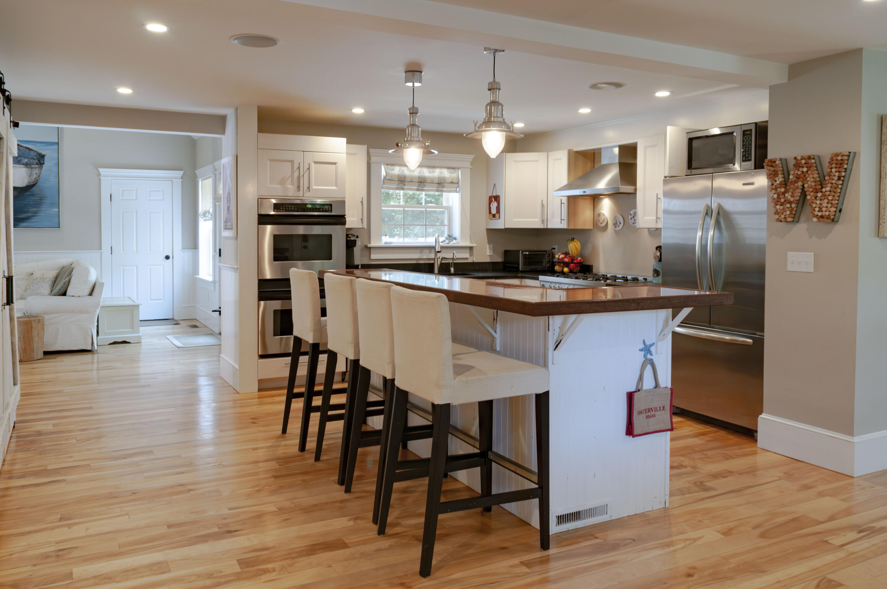 1774 South County Road Osterville, MA 02655 - Photo 26 of 75 a kitchen with stainless steel appliances kitchen island granite countertop a table chairs refrigerator and microwave