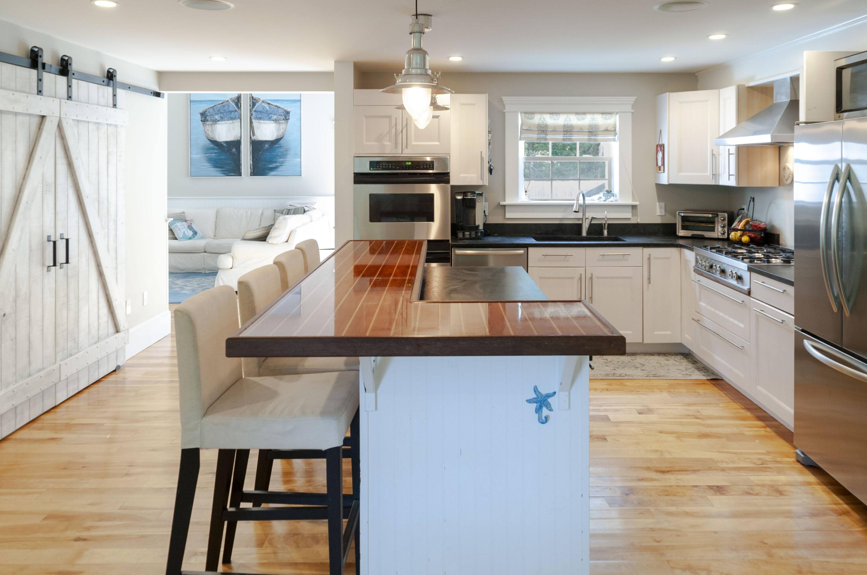 1774 South County Road Osterville, MA 02655 - Photo 27 of 75 a kitchen with stainless steel appliances granite countertop a sink a stove and a refrigerator