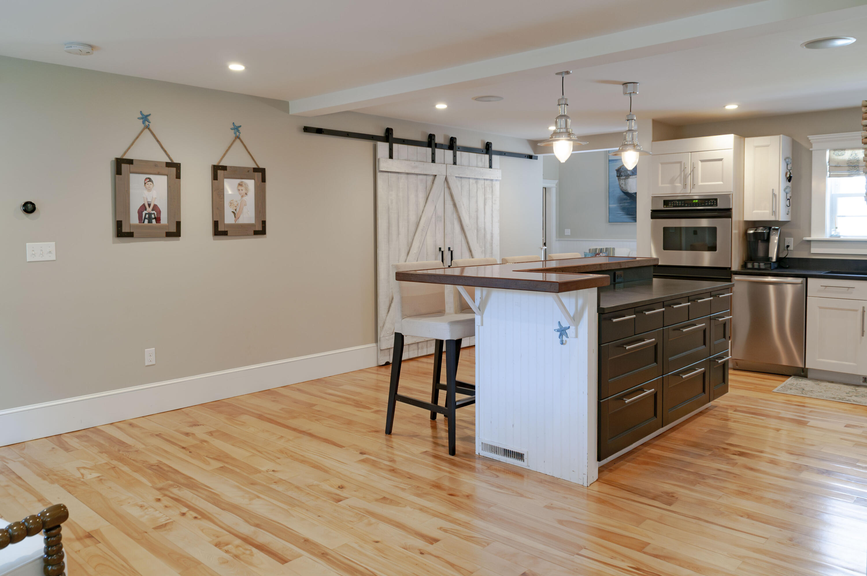 1774 South County Road Osterville, MA 02655 - Photo 33 of 75 a kitchen with stainless steel appliances granite countertop a table chairs stove and wooden floor