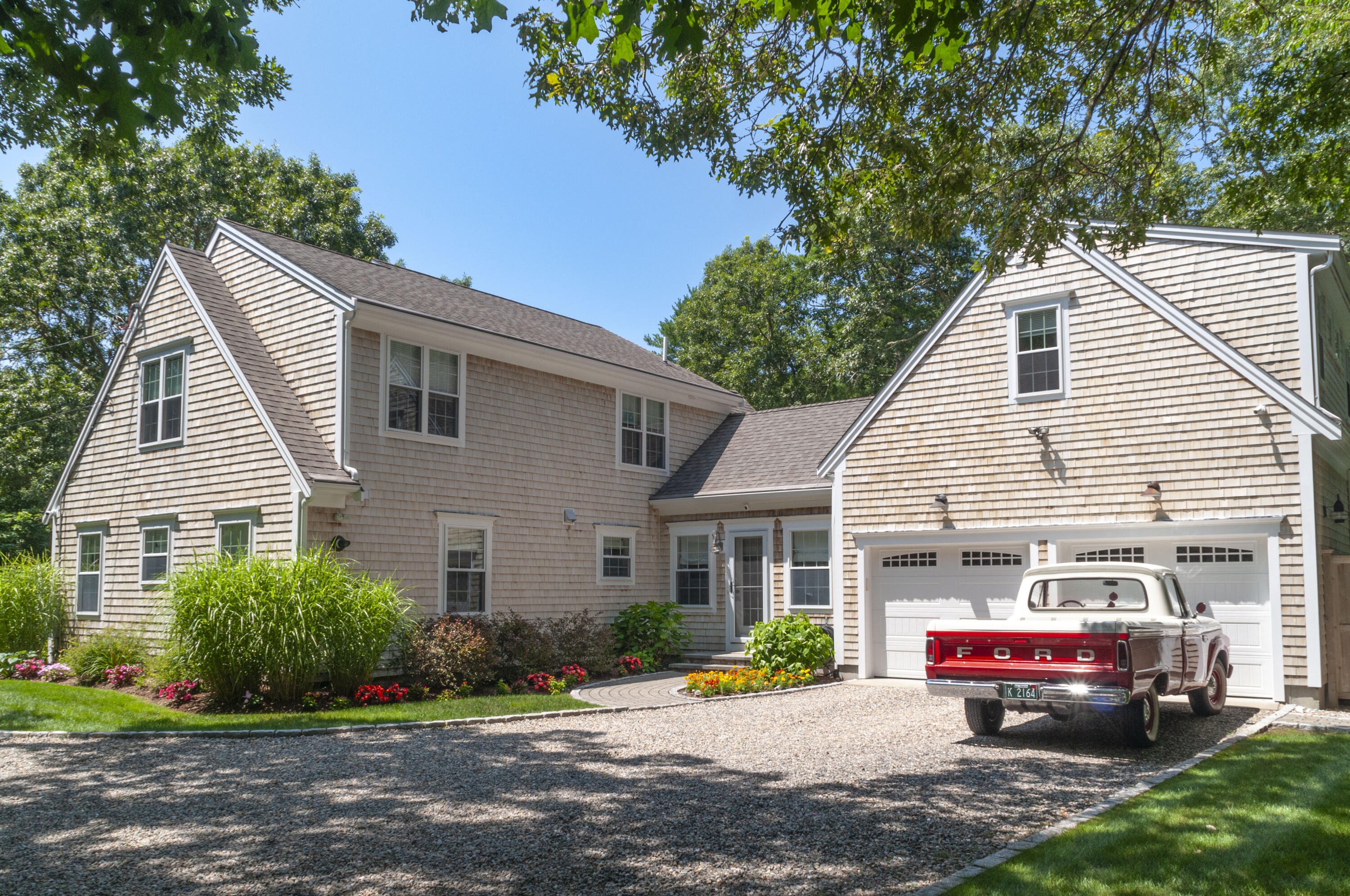 1774 South County Road Osterville, MA 02655 - Photo 5 of 75 a front view of a house with a yard and potted plants