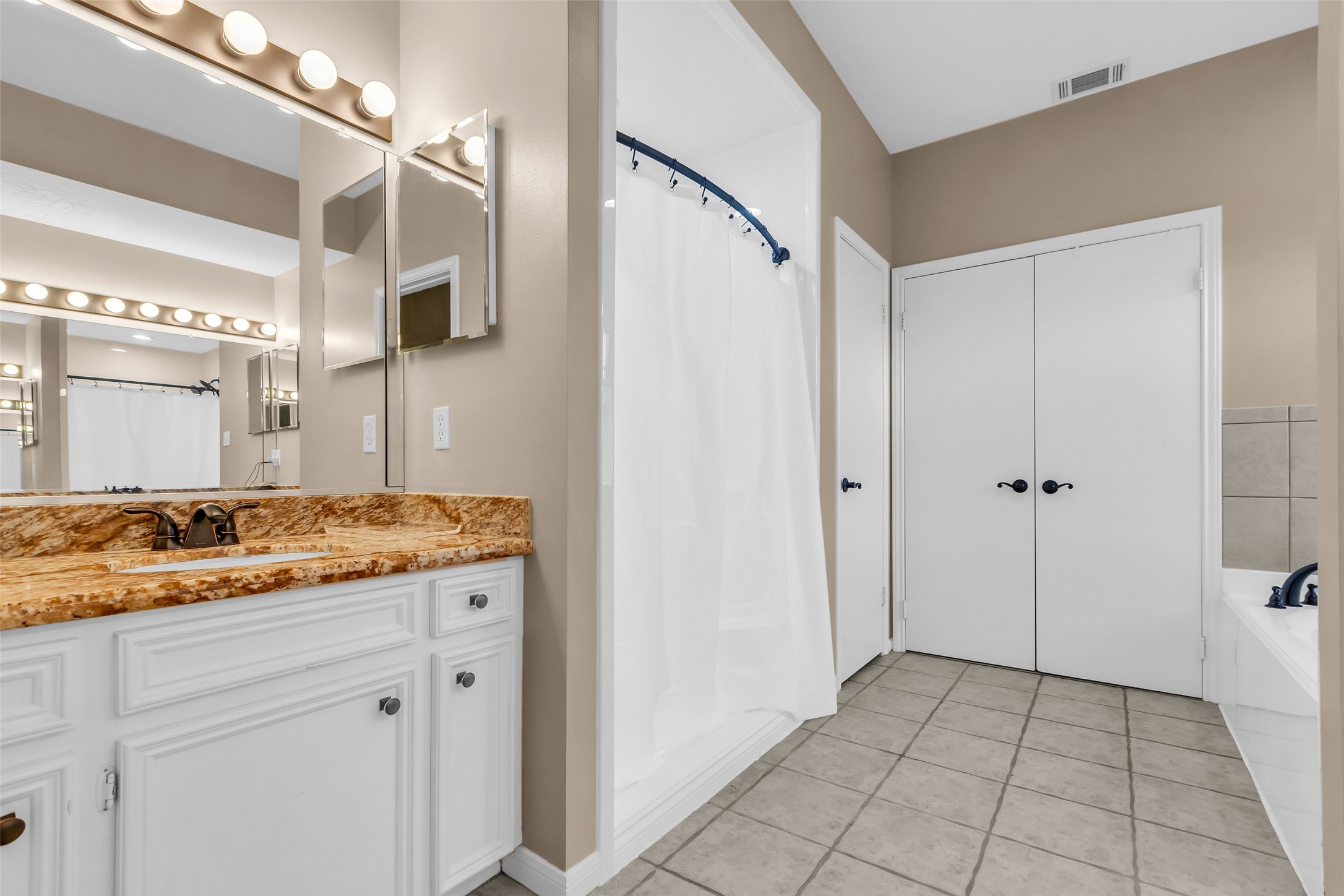 28414 Dobbin-Huffsmith Road Magnolia, TX 77354 - Photo 16 of 39 a bathroom with a granite countertop sink a mirror and a shower