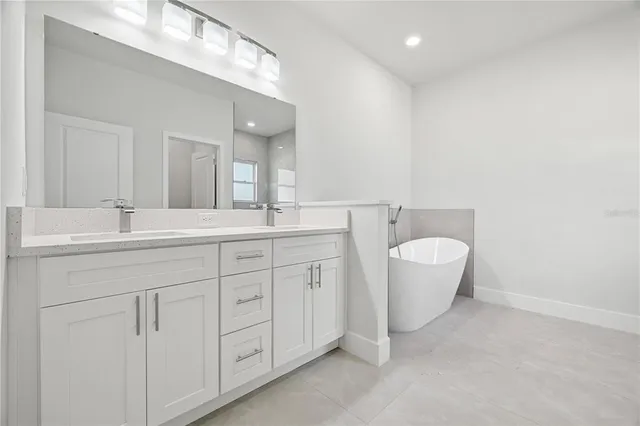 a bathroom with a granite countertop sink mirror and bathtub