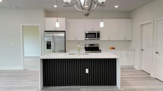 a kitchen with stainless steel appliances a sink and a refrigerator