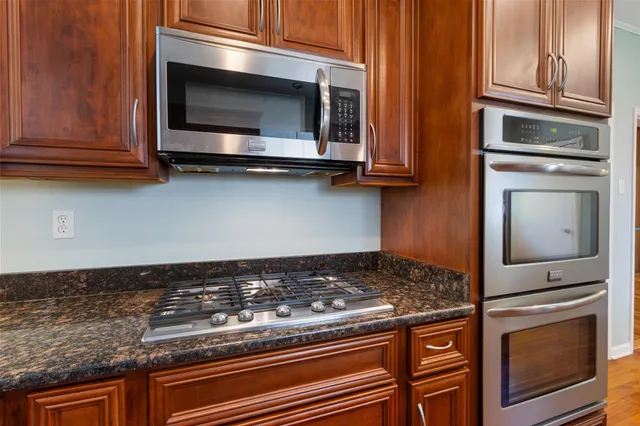 a kitchen with granite countertop stainless steel appliances and cabinets
