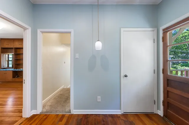 a view of a hallway with wooden floor and front door
