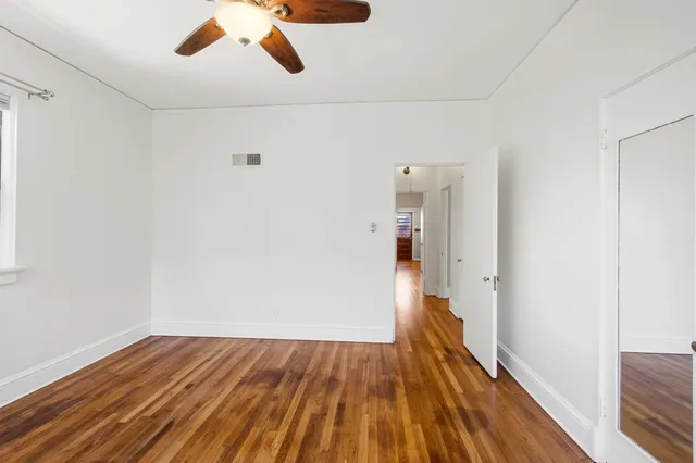 a view of empty room with wooden floor