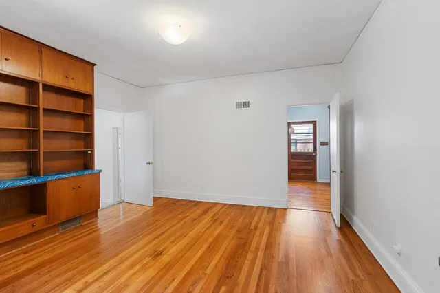 a view of empty room with wooden floor and closet