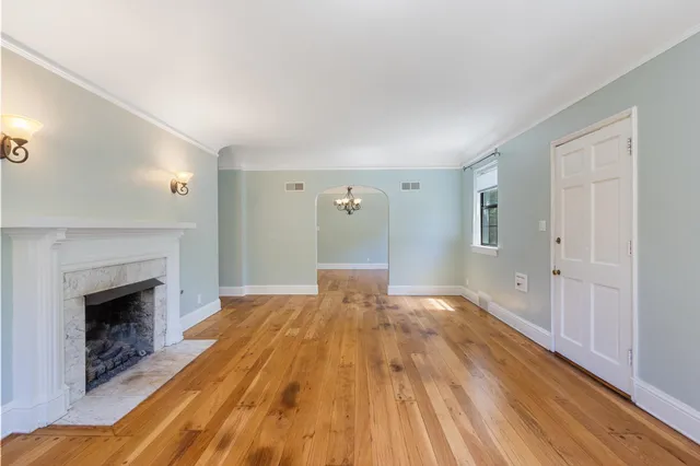 a view of empty room with wooden floor and fireplace