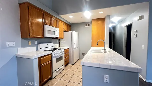 a kitchen with stainless steel appliances granite countertop a refrigerator a stove and a sink