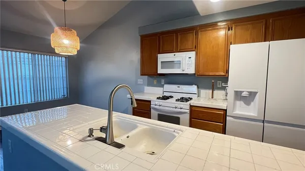 a kitchen with granite countertop a sink stainless steel appliances and cabinets