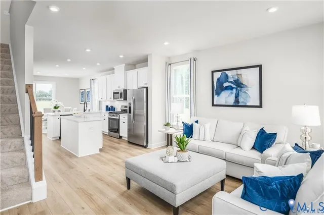 a living room with furniture and kitchen view