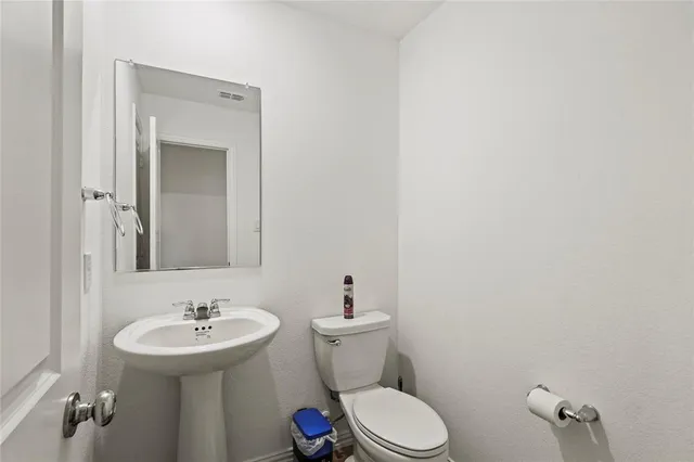 a bathroom with a sink mirror vanity and toilet