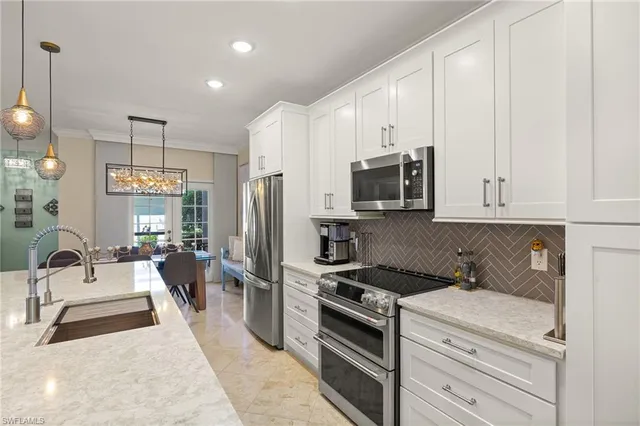 a kitchen with cabinets and chandelier