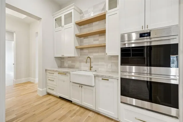 a kitchen with stainless steel appliances cabinets and wooden floor