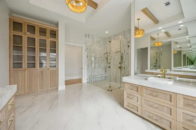 a spacious bathroom with a granite countertop sink a toilet a mirror and shower