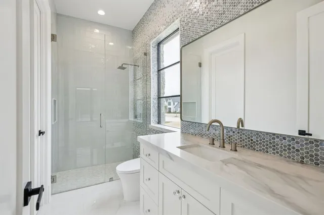 a bathroom with a double vanity sink toilet and shower