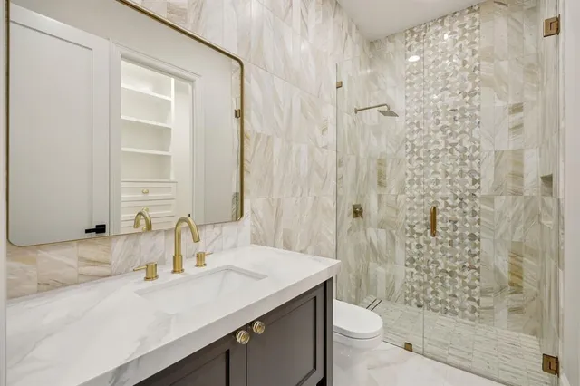 a bathroom with a granite countertop sink toilet and shower